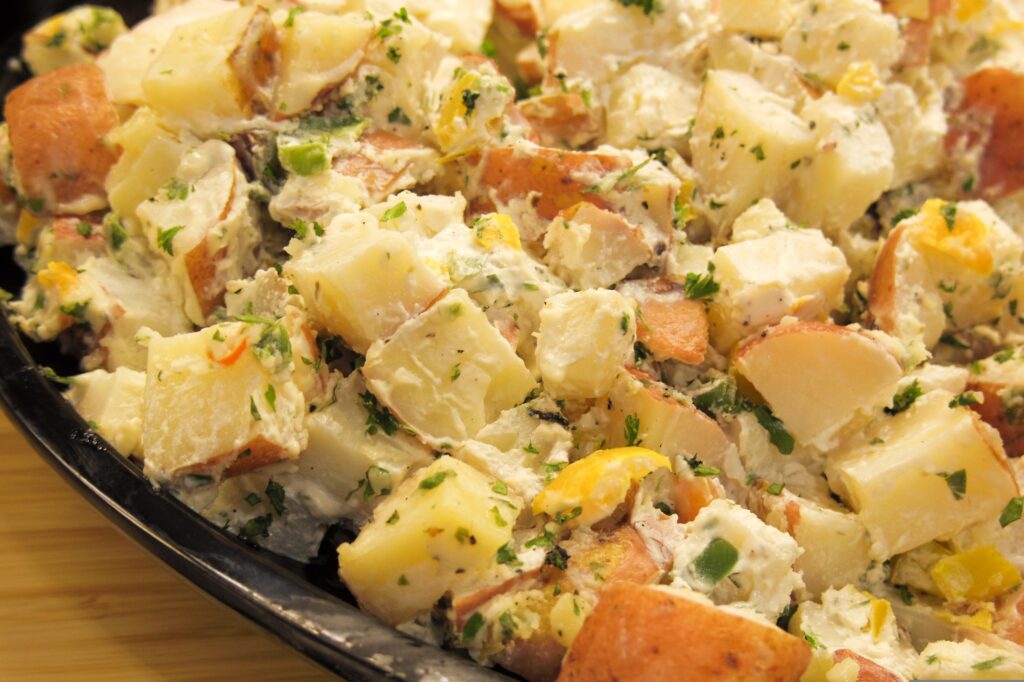 Close-up of creamy potato salad with herbs and red-skinned potatoes