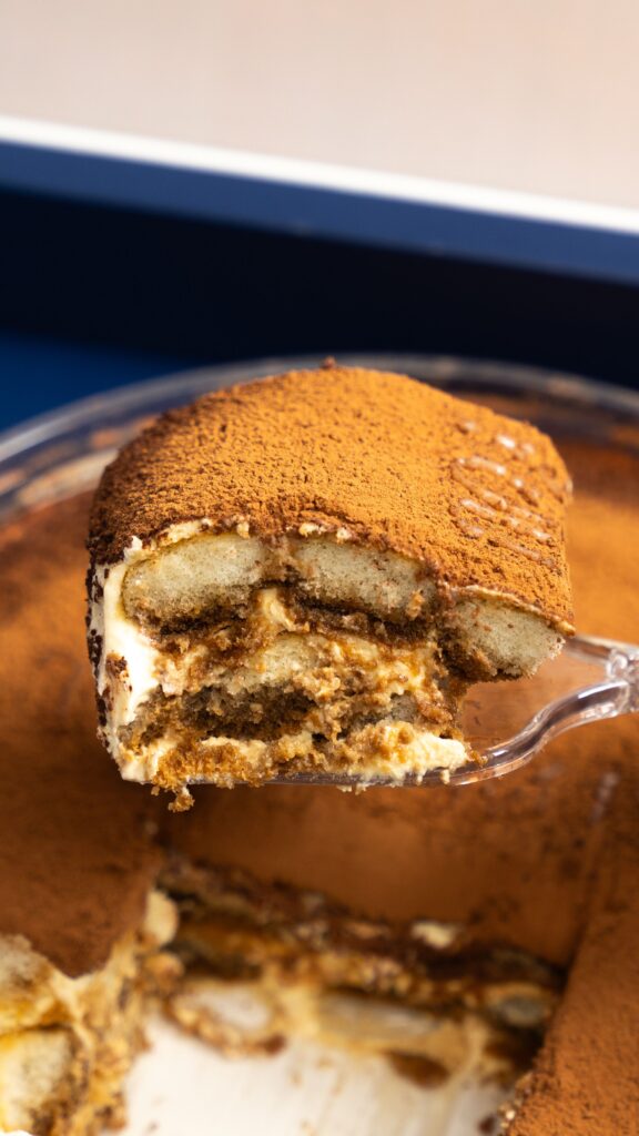 Forkful of tiramisu showing layered mascarpone and coffee-soaked ladyfingers