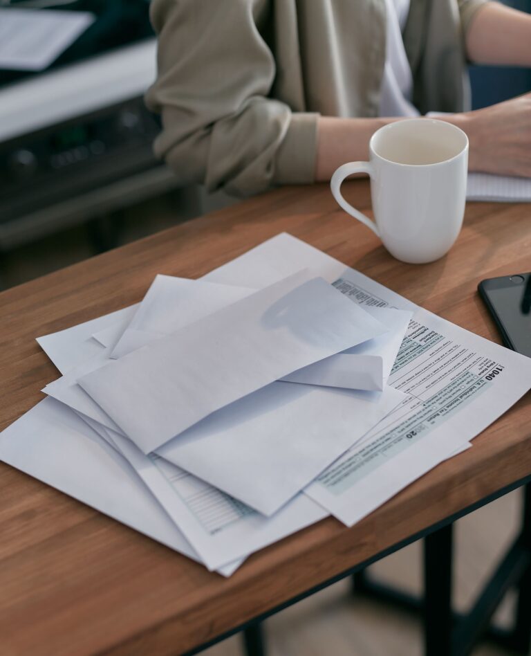 Cluttered kitchen counter covered in mail and paper clutter