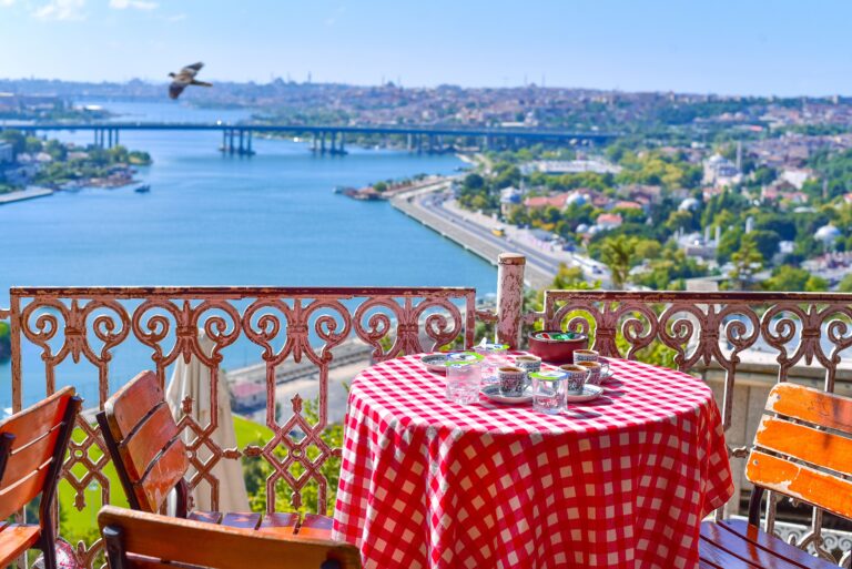 Traveling without seeing everything — a quiet café table overlooking the water