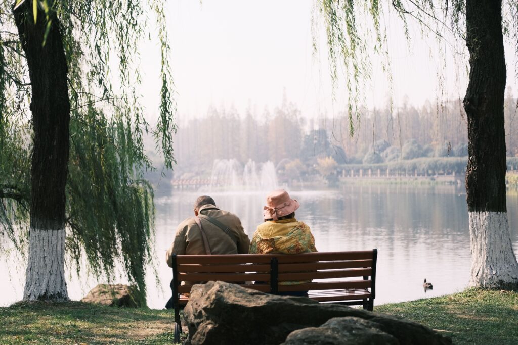 traveling without seeing everything. Couple sitting quietly by a lake, representing unhurried travel moments