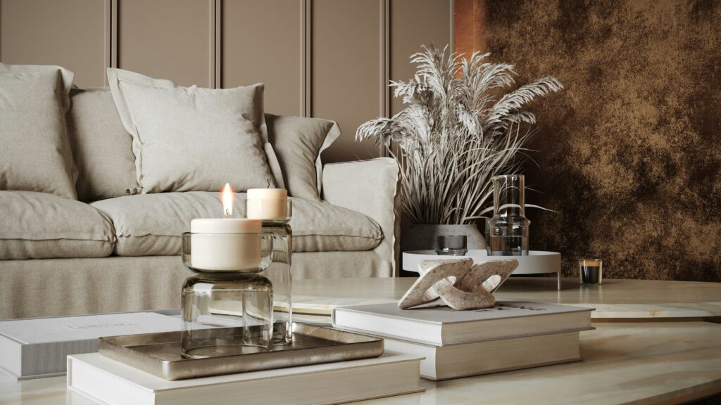 Cozy living room styled with lit candles, books, and dried pampas grass