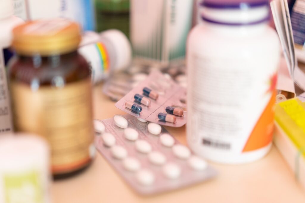 Close-up of pill bottles and blister packs of medication on a counter